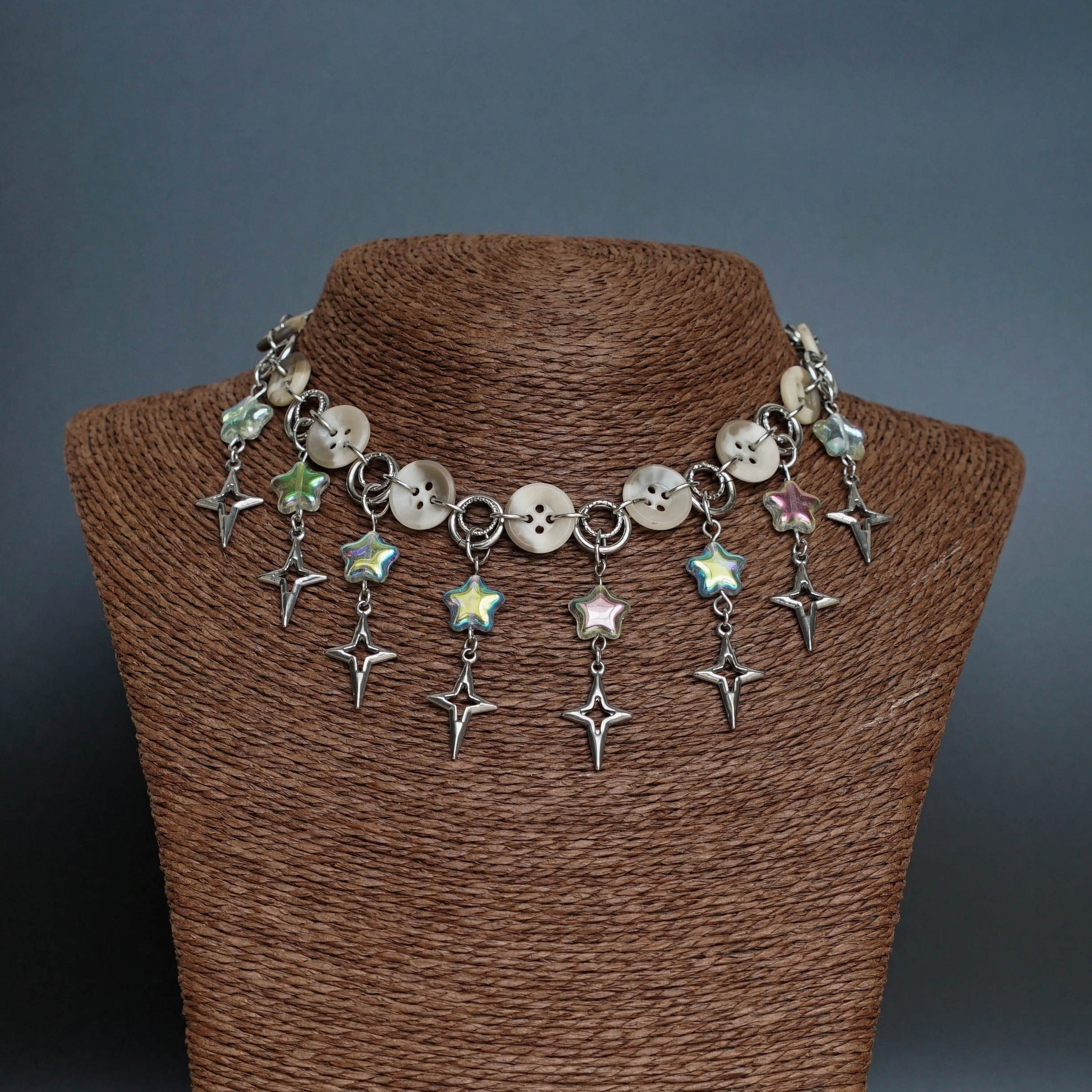 Necklace with star-shaped charms on a brown mannequin against a dark background